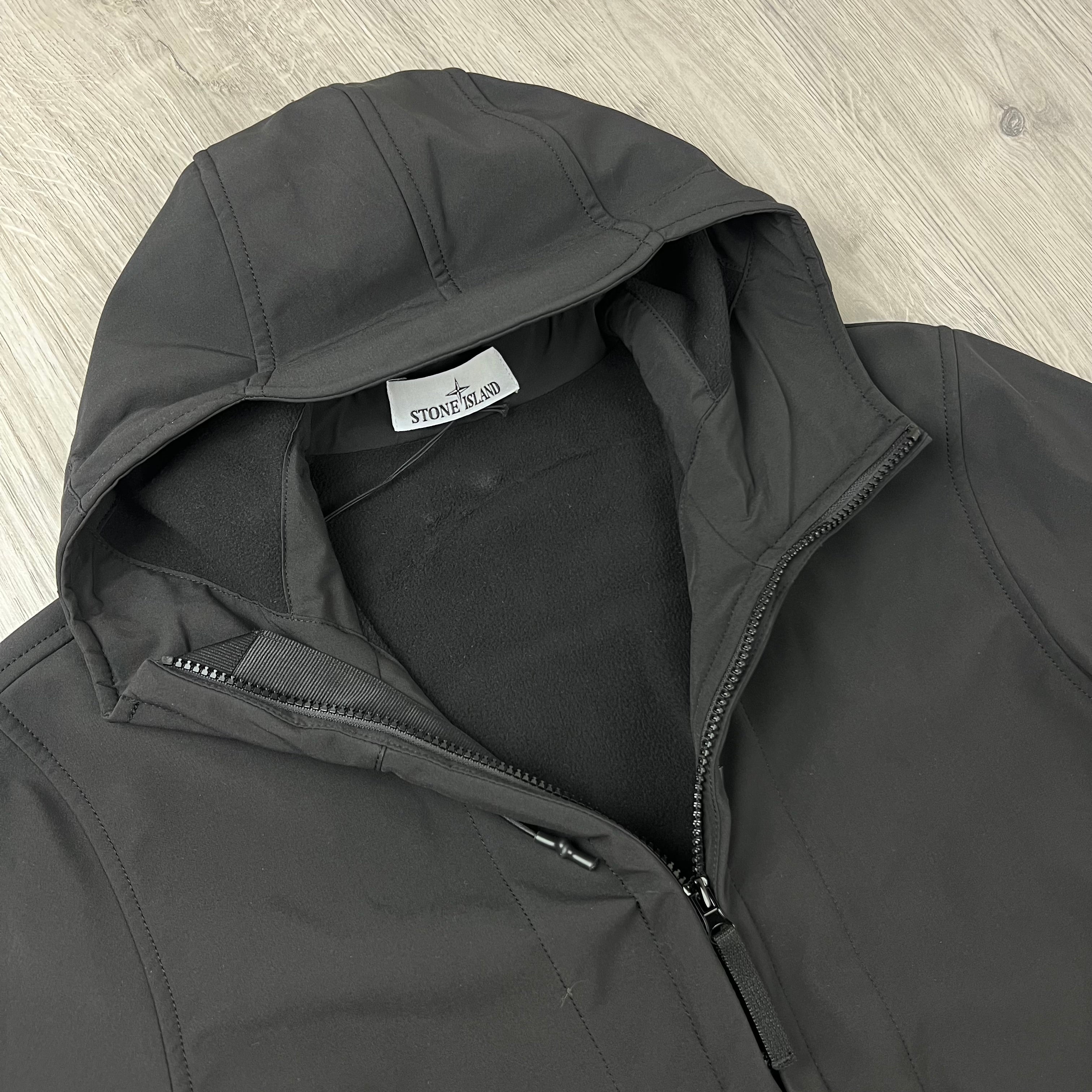 A close up view of the hood on a Stone Island Soft Shell-R_e.dye® Jacket in Black.
