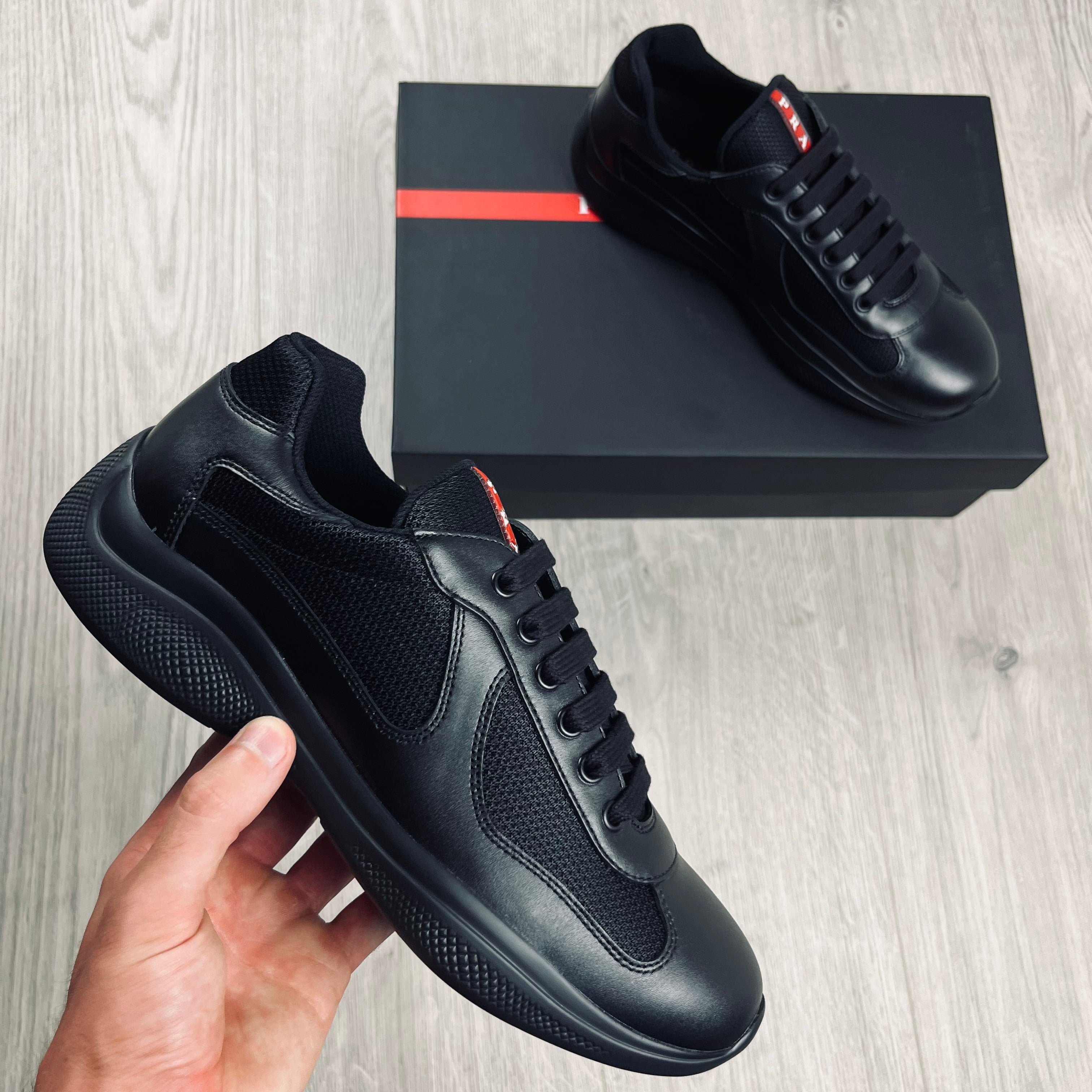 Prada Americas Cup Sneakers in Black. On sale at Open Attire