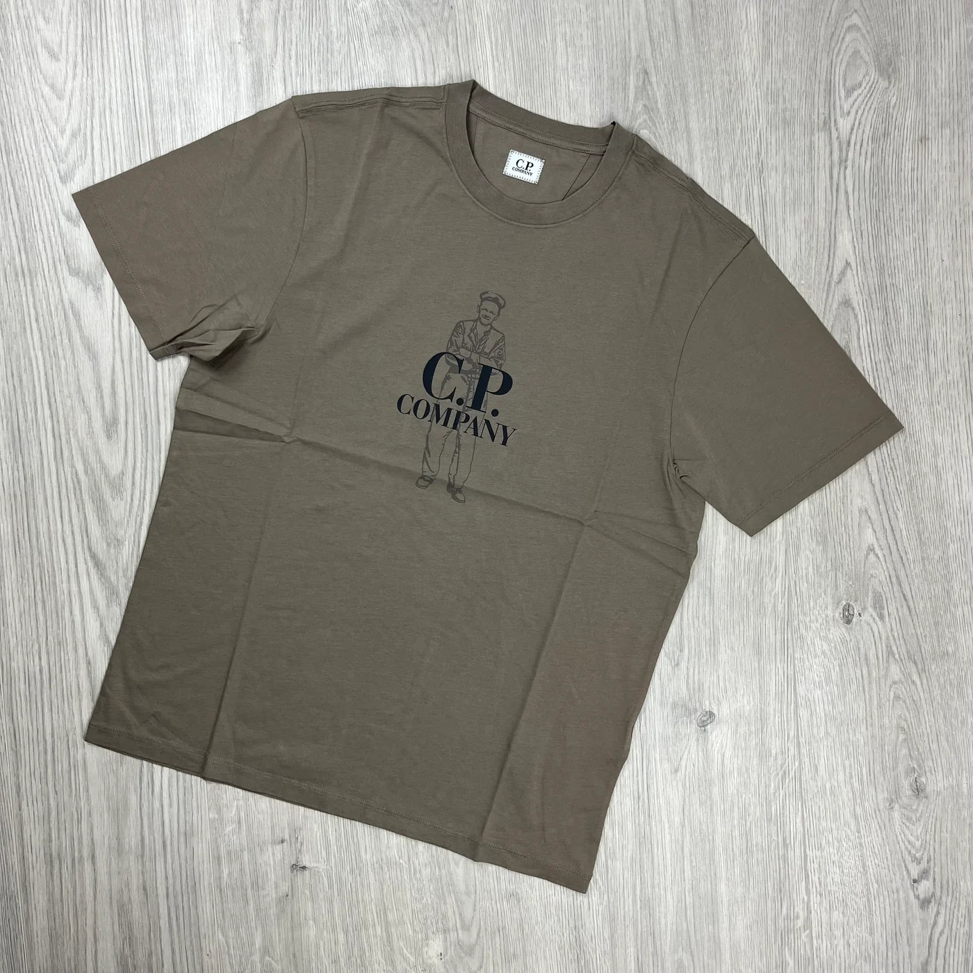 CP Company Tracksuit consisting of a Walnut T-shirt and Black jersey shorts. On sale at Open Attire.