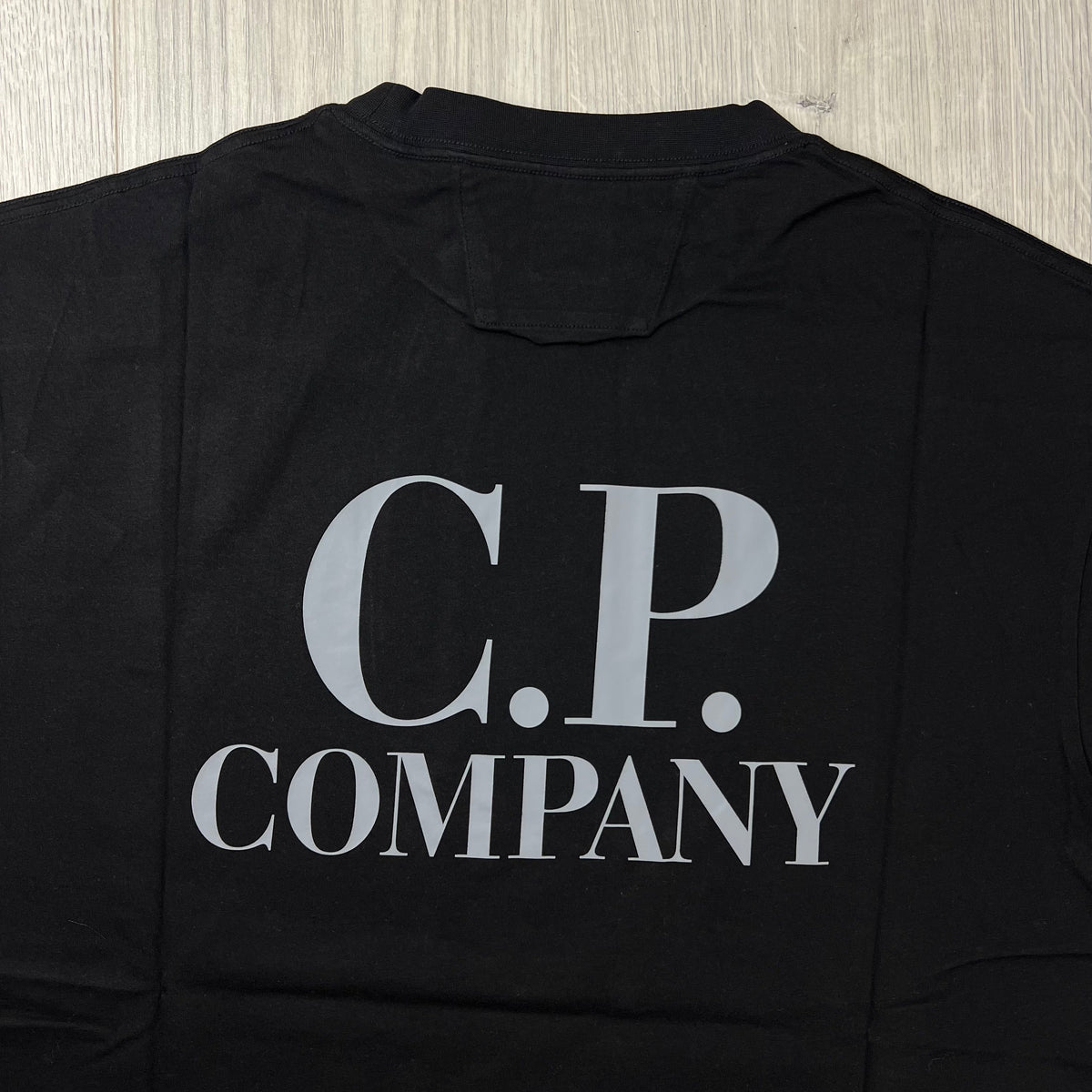 Close up view of a CP Company 30/1 Logo T-Shirt in Black. 
